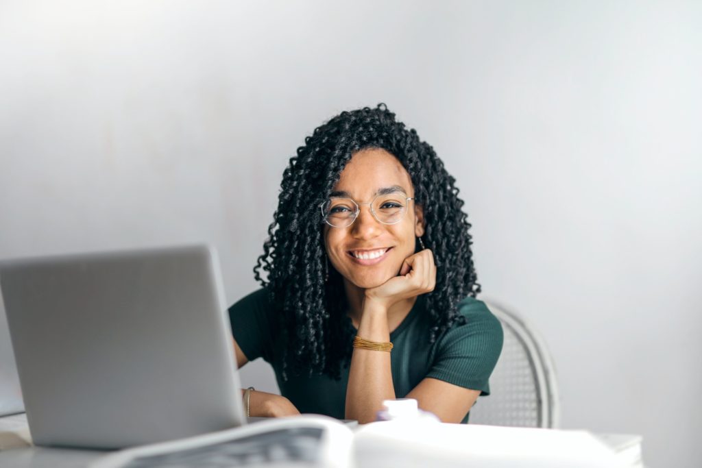 LMS, se muestra una joven afroamericana sonriente detras de una laptop