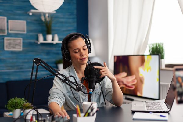 Cómo hacer un curso en línea, persona toca el micrófono para probar el sonido antes de su grabación.