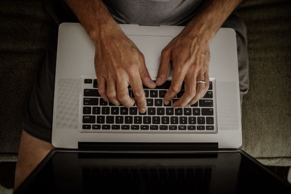 Ejemplos de Ims; presentación de cenital de una imagen de un hombre escribiendo en su computadora portátil mientras usa una plataforma virtual.