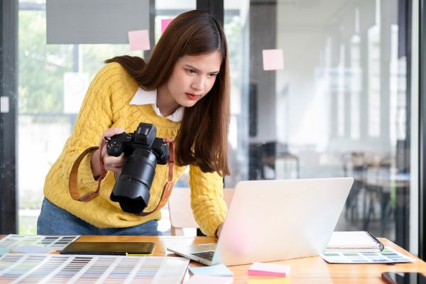 Plataformas de cursos; presentación de una joven tomando un curso vía online de fotografía por medio de una computadora portátil de manera práctica.