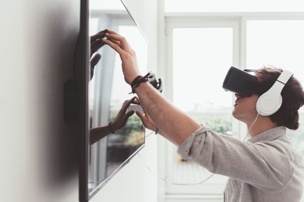 Que es gamificación, adulto joven aprendiendo y jugando videojuego con visor 3D.