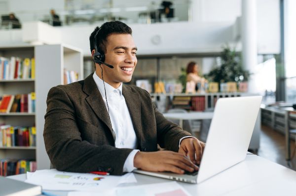 Gamificación ventajas y desventajas; imagen de un hombre con auriculares tomando un curso para llevar a cabo mejores estrategias mediante la gamificación empresarial.