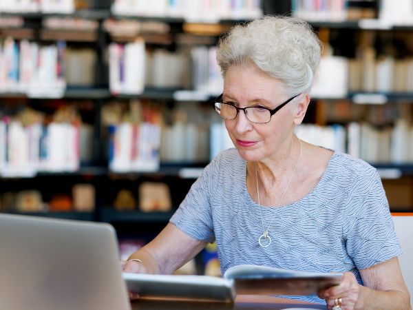 LMS ventajas; imagen de una mujer de la tercera edad tomando un curso online complementando ideas para un aprendizaje eficaz.