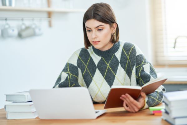 Plataformas para dar clases online; imagen de una joven tomando clases con diversas herramientas de estudio siendo una plataforma la principal.