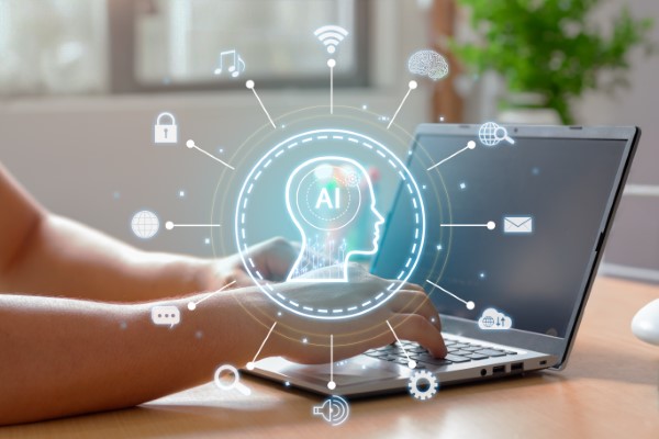 Inteligencia artificial en la educación; imagen de una persona escribiendo en su computadora portátil mientras se muestra una ilustración de la IA como eje conductual para llevar a cabo un aprendizaje de calidad.