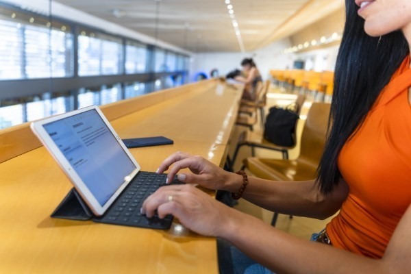 Educación personalizada; imagen de una mujer usando su dispositivo para el aprendizaje de una manera práctica y flexible.