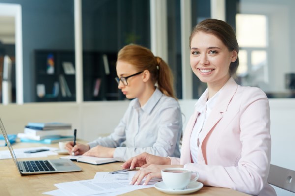 Cursos de capacitación para empresas; Mujer sonriendo mientras trabaja