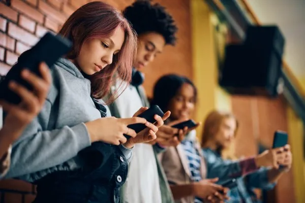 Grupo de jóvenes interactuando con su celular.